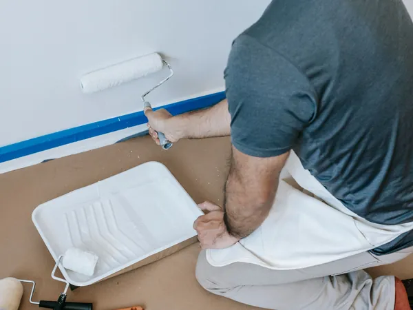 Pintura de una pared con rodillo y el suelo protegido con papel, como lo preparo antes de pintar